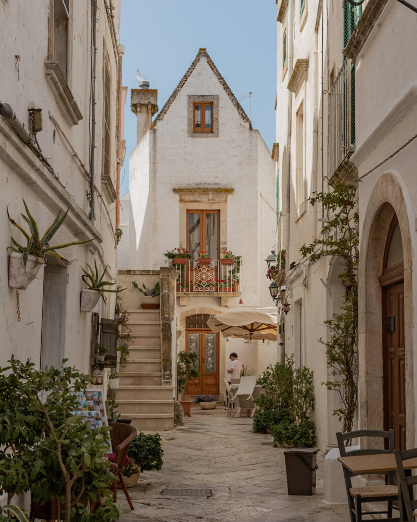 Puglia Itinerary: U Curdunn restaurant in Locorotondo. A whitewashed corner building in a narrow alley.