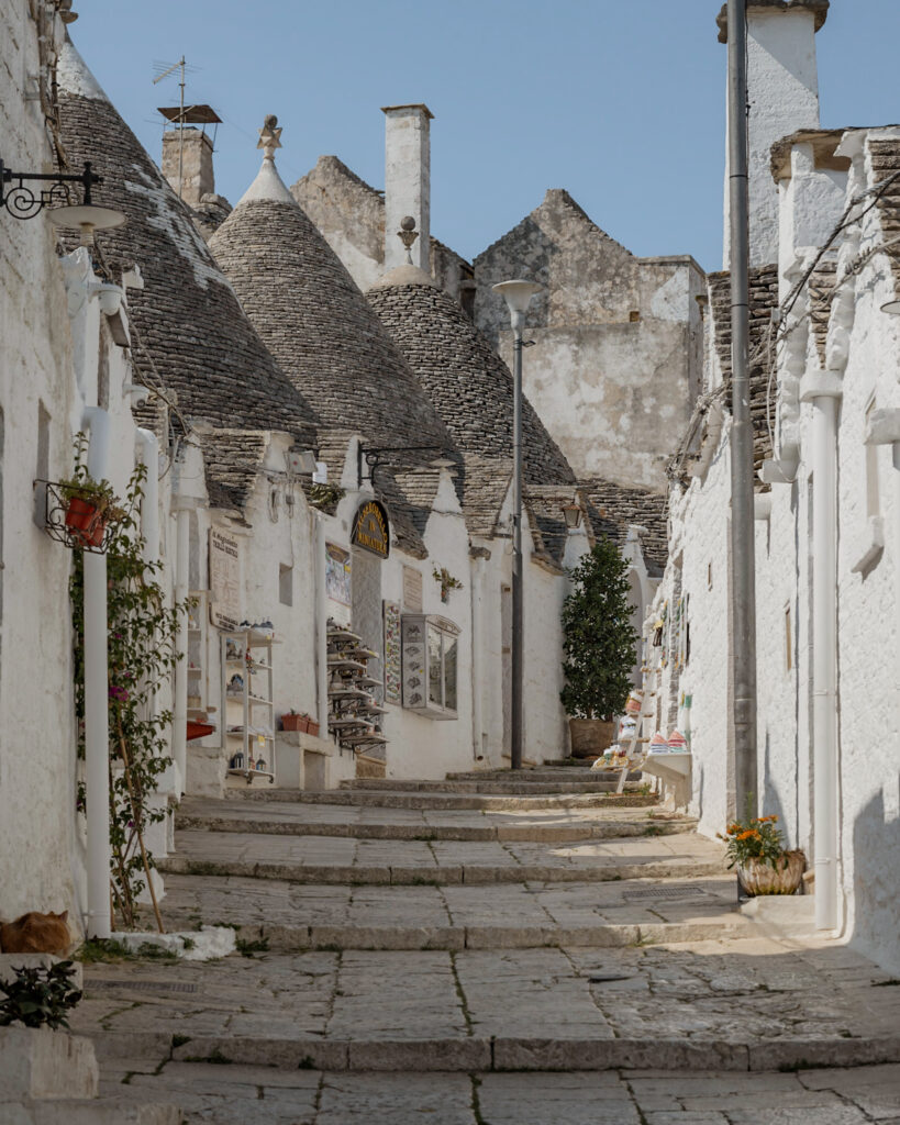 Puglia Itinerary: a little street full of the iconic trulli of Alberobello.