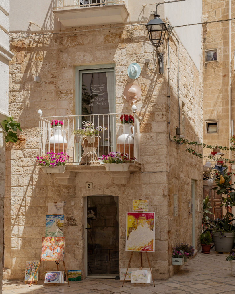 Puglia Itinerary: a charming corner building with natural stone walls and artwork.