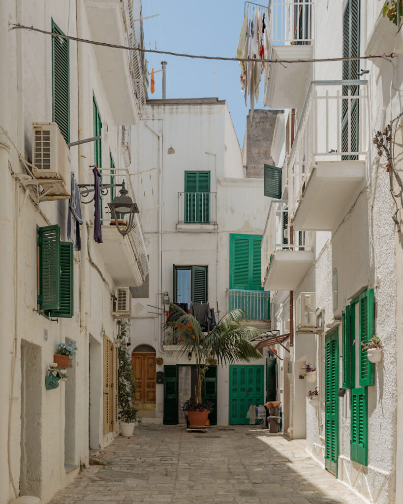 Puglia Itinerary: a white cul de sac with green shutters and doors.