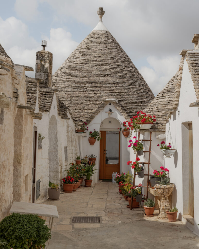 Puglia Itinerary: a trullo with flowers in front.